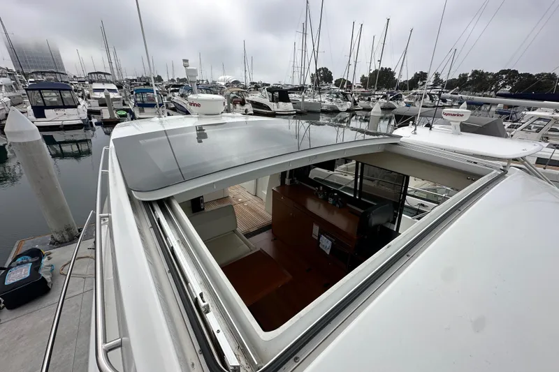Slide: The Image of 2015 Jeanneau NC11 yacht with open sunroof, docked in a marina. - 23