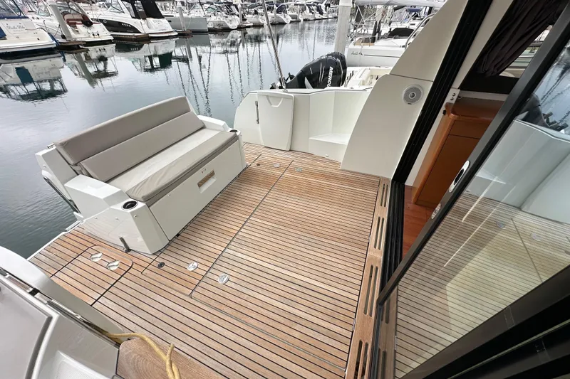 Slide: The Image of 2015 Jeanneau NC11 yacht with teak deck and seating at marina. - 27