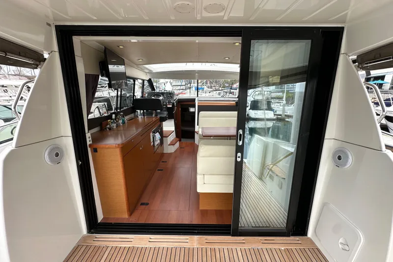 Slide: The Image of Interior view of 2015 Jeanneau NC11 yacht with modern furnishings and sliding glass door. - 28