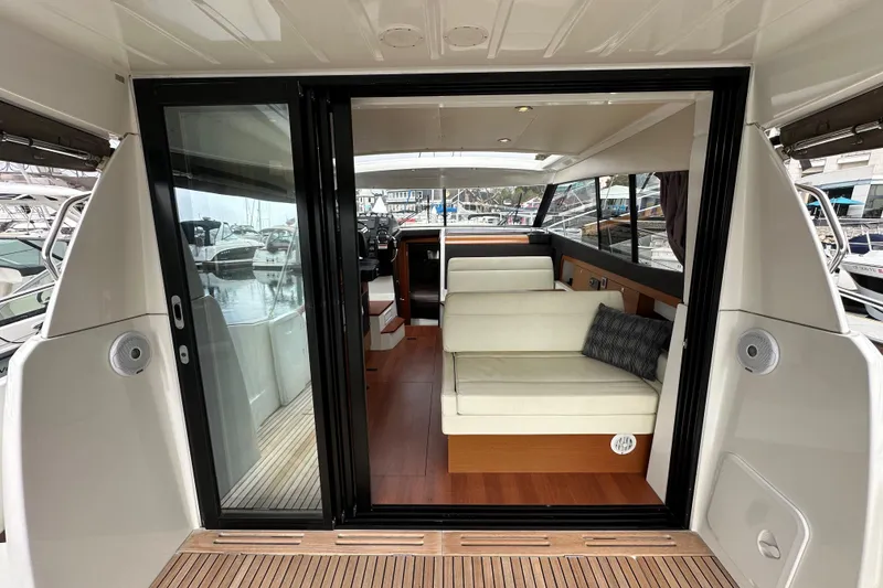 Slide: The Image of 2015 Jeanneau NC11 yacht interior with sliding glass doors and comfortable seating. - 29