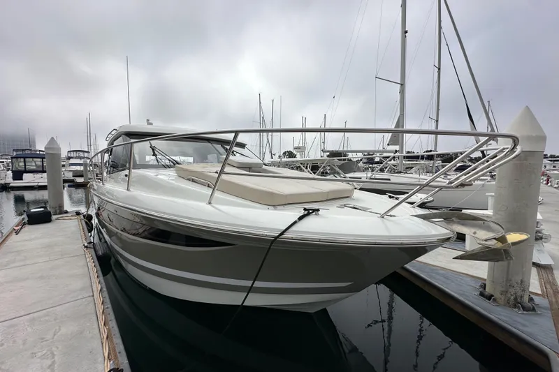 Slide: The Image of 2015 Jeanneau NC11 yacht docked at marina, overcast sky, sleek design. - 3