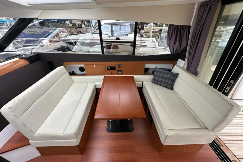 Slide: The Image of Interior of 2015 Jeanneau NC11 yacht with elegant seating and wooden table. - 36