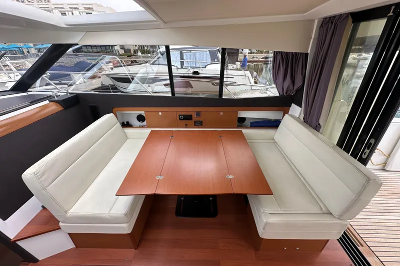 Slide: The Image of Interior of 2015 Jeanneau NC11 boat with dining area and wooden table. - 37