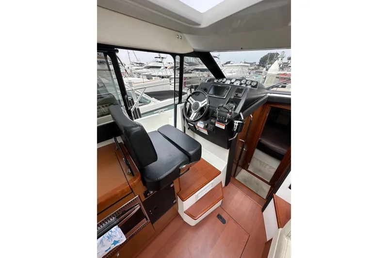 Slide: The Image of 2015 Jeanneau NC11 boat interior with helm, steering wheel, and control panel. - 39