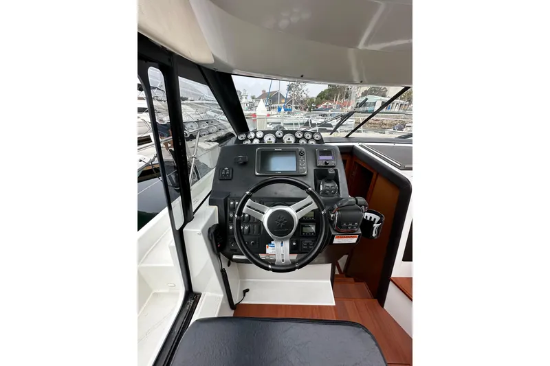 Slide: The Image of Helm of 2015 Jeanneau NC11 boat with steering wheel and navigation controls. - 40