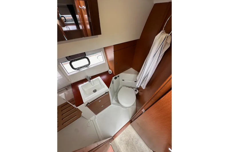 Slide: The Image of 2015 Jeanneau NC11 bathroom interior with sink, toilet, and wooden accents. - 47