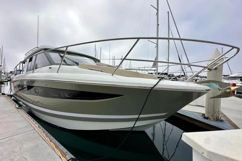 Slide: The Image of 2015 Jeanneau NC11 yacht docked at marina, sleek design, overcast sky. - 5