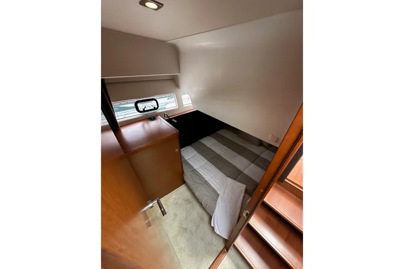 Slide: The Image of Cozy cabin interior of 2015 Jeanneau NC11 boat with bed and wooden furnishings. - 52