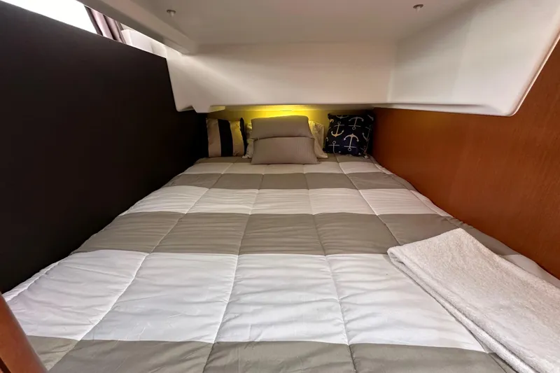 Slide: The Image of Cozy cabin bed in 2015 Jeanneau NC11 yacht with nautical-themed pillows. - 53