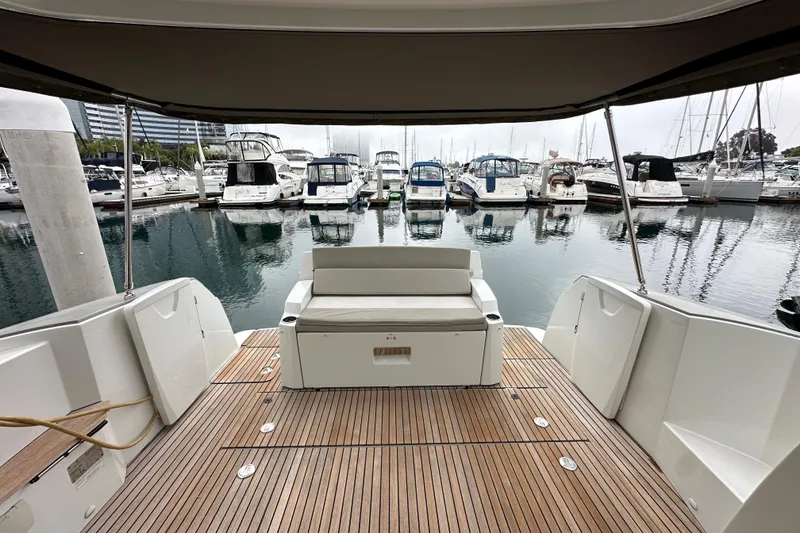 Slide: The Image of 2015 Jeanneau NC11 boat with teak deck, docked at a marina with multiple yachts. - 66