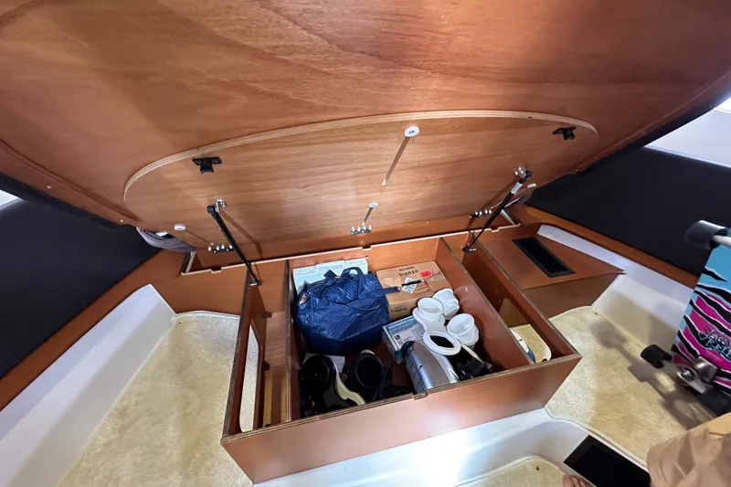 Slide: The Image of Storage compartment in a 2015 Jeanneau NC11 boat, containing various items and equipment. - 68