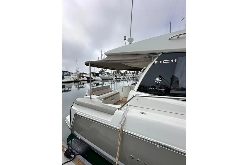 Slide: The Image of 2015 Jeanneau NC11 yacht docked at marina, showcasing sleek design and modern features. - 8