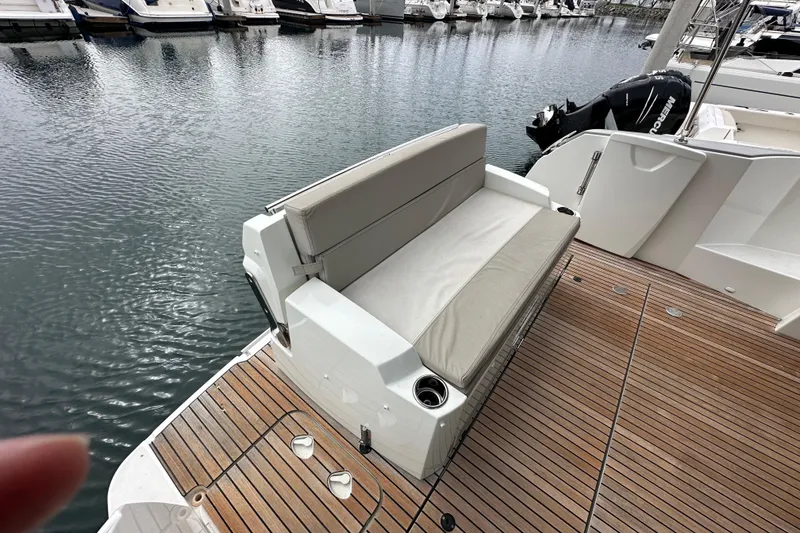Slide: The Image of 2015 Jeanneau NC11 boat with cushioned seating on teak deck at marina. - 81