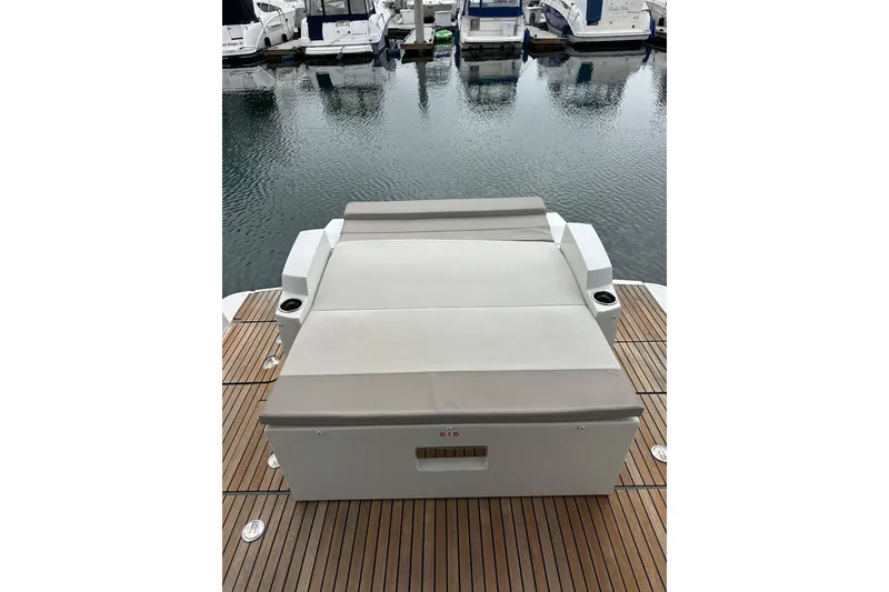 Slide: The Image of 2015 Jeanneau NC11 yacht with cushioned sunbed on teak deck, docked at marina. - 82