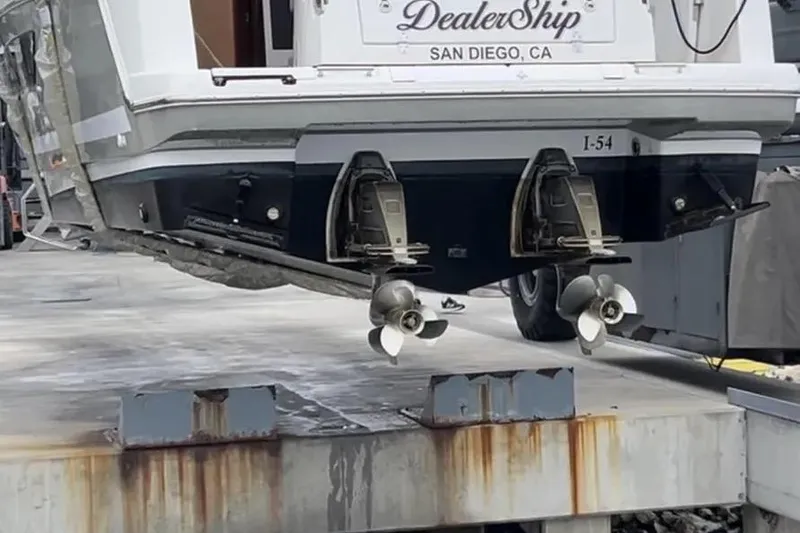 Slide: The Image of 2015 Jeanneau NC11 boat with dual propellers, displayed at a San Diego dealership. - 86