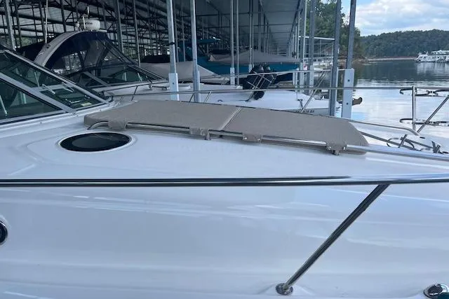 Slide: The Image of 2005 Sea Ray 320 Sundancer docked in a marina, showcasing sleek design and spacious deck. - 11