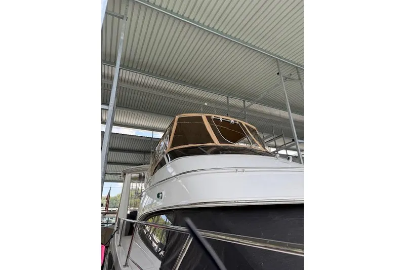 Slide: The Image of 2005 Sea Ray 320 Sundancer yacht docked under a metal canopy. - 12