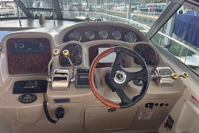 Slide: The Image of 2005 Sea Ray 320 Sundancer helm with gauges, steering wheel, and controls. - 14