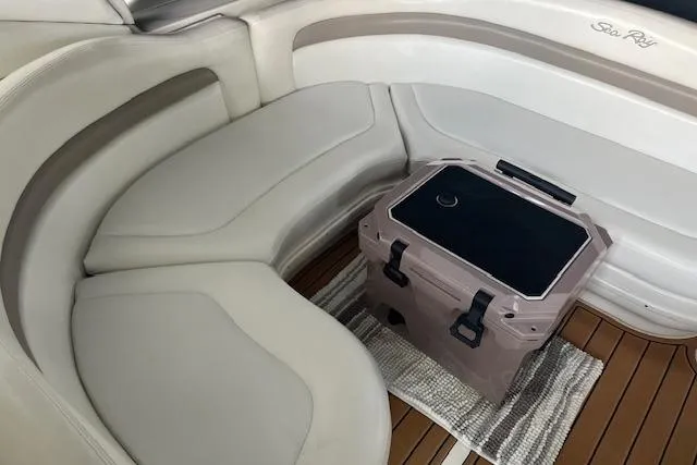 Slide: The Image of 2005 Sea Ray 320 Sundancer interior with cushioned seating and portable cooler on teak flooring. - 22