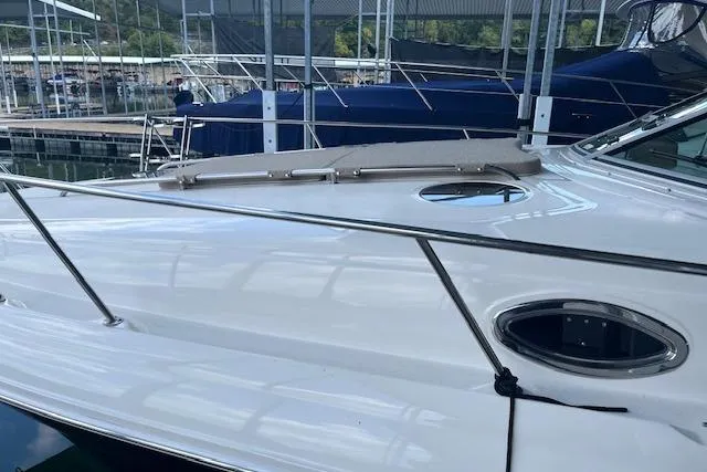 Slide: The Image of 2005 Sea Ray 320 Sundancer yacht docked at marina, showcasing sleek white exterior. - 4