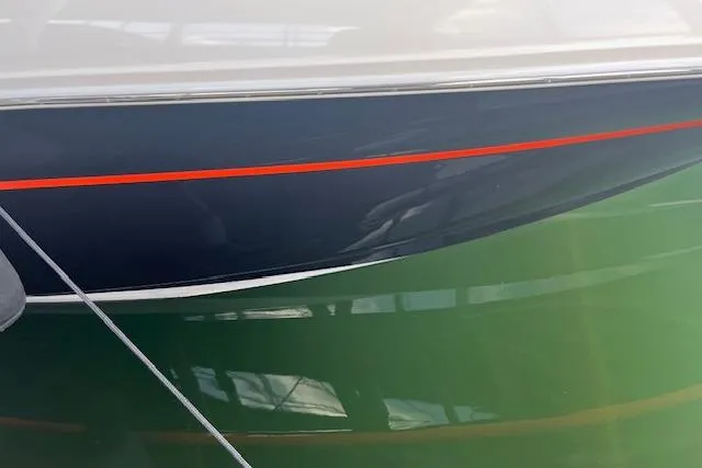 Slide: The Image of 2005 Sea Ray 320 Sundancer boat hull with red stripe, reflecting on water. - 8