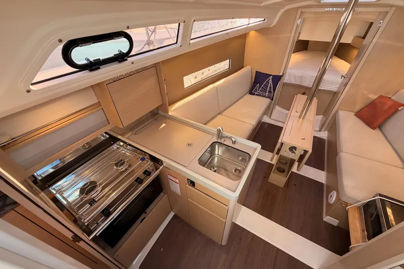 Slide: The Image of Interior of 2020 Beneteau Oceanis 30.1 yacht, featuring kitchen, seating, and sleeping area. - 27