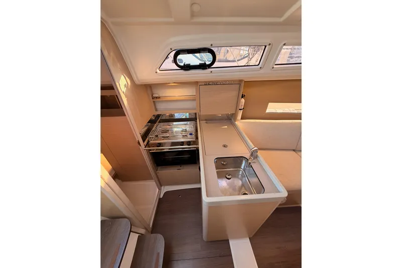 Slide: The Image of Interior of 2020 Beneteau Oceanis 30.1 yacht, featuring a compact kitchen area. - 28