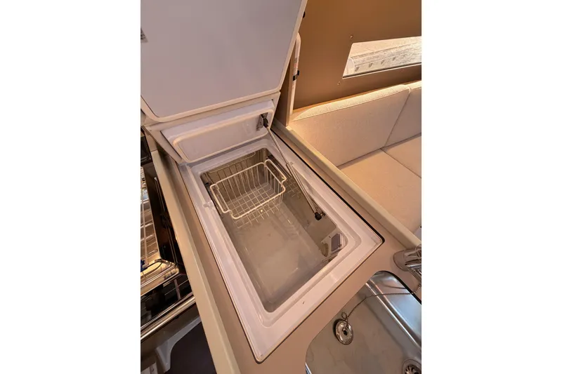 Slide: The Image of Interior view of 2020 Beneteau Oceanis 30.1 yacht kitchen with open refrigerator. - 29