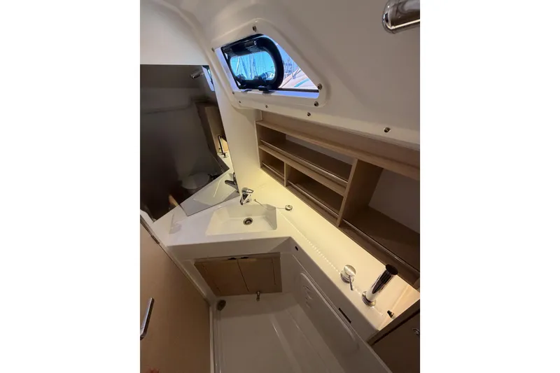 Slide: The Image of Interior of 2020 Beneteau Oceanis 30.1 yacht bathroom with sink and storage shelves. - 32