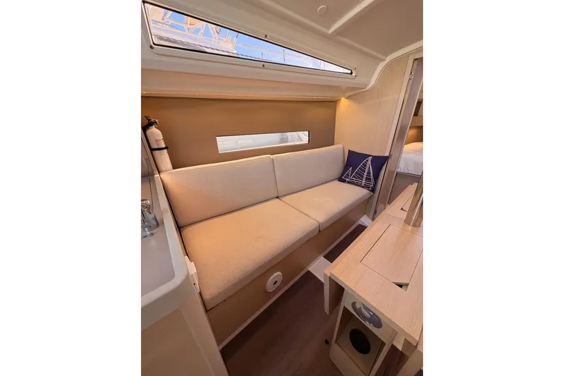 Slide: The Image of Interior of 2020 Beneteau Oceanis 30.1 yacht with beige seating and nautical decor. - 36