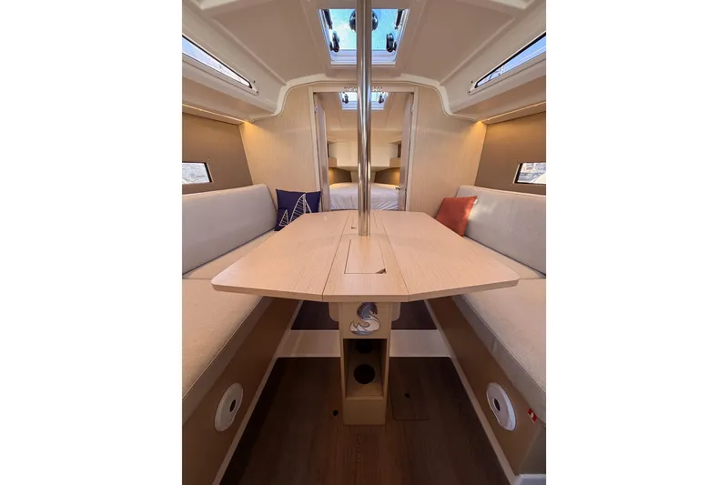 Slide: The Image of Interior of 2020 Beneteau Oceanis 30.1 sailboat, featuring a cozy dining area with natural light. - 39