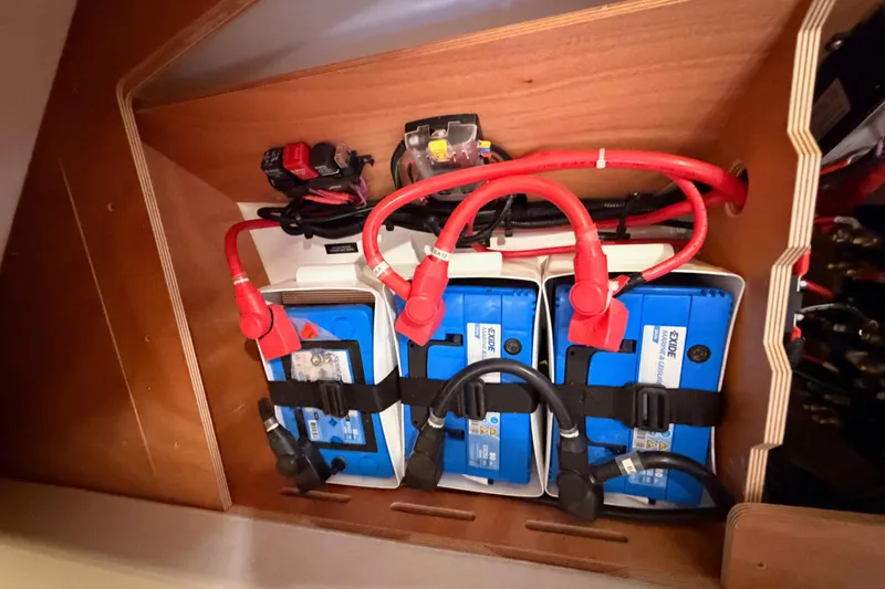 Slide: The Image of Battery compartment of 2020 Beneteau Oceanis 30.1 with red cables and Exide batteries. - 51