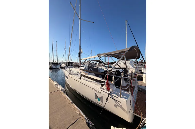 Slide: The Image of 2020 Beneteau Oceanis 30.1 sailboat docked at marina under clear blue sky. - 61