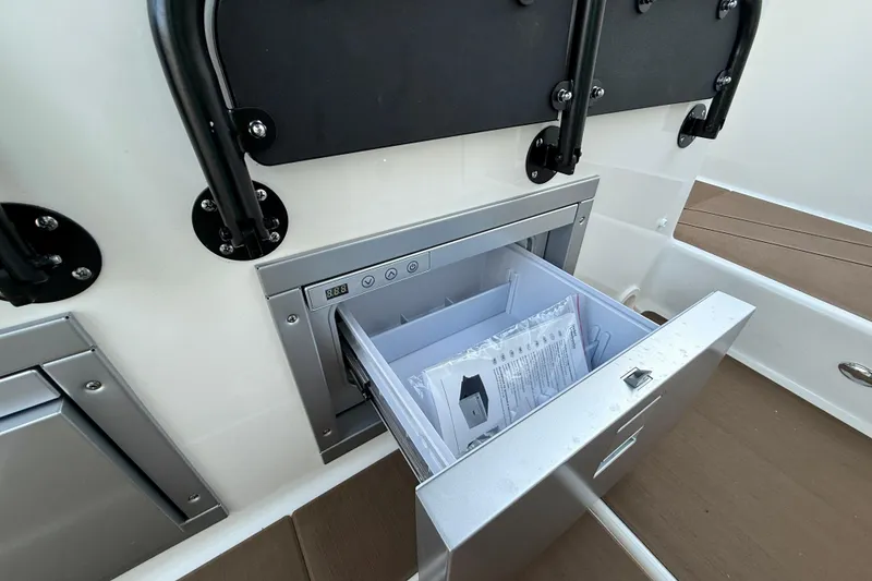 Slide: The Image of Open storage compartment in 2026 Navan S30 boat, featuring a digital control panel. - 21