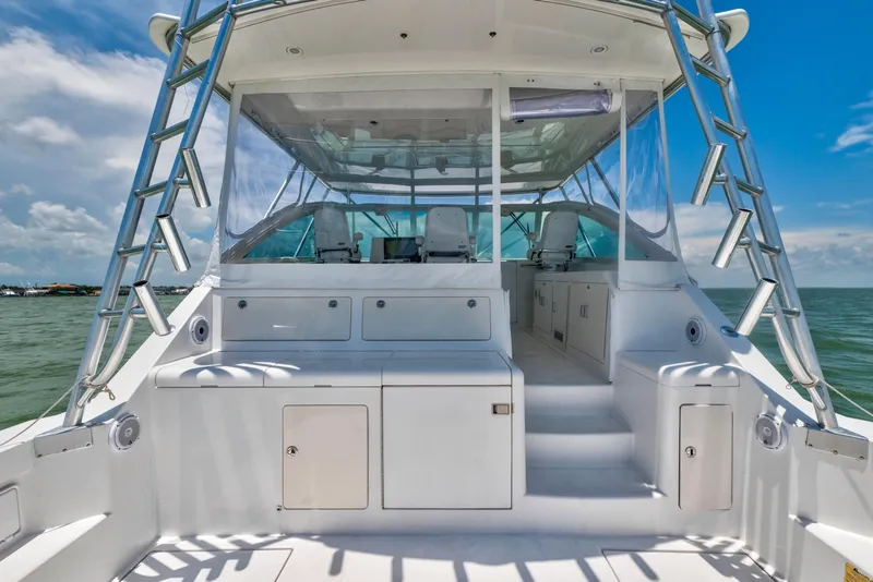 Slide: The Image of 2010 Cabo 45 Express yacht interior with seating, ocean view, and clear skies. - 13