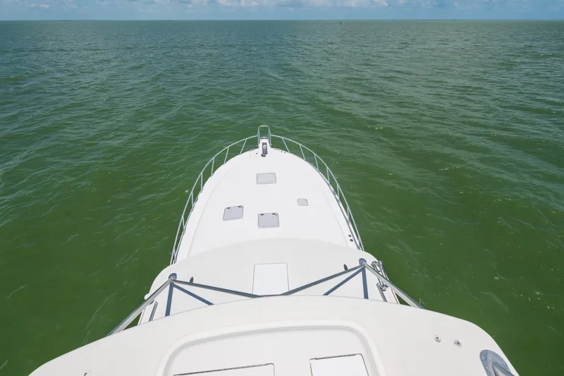 Slide: The Image of Bow view of 2010 Cabo 45 Express yacht cruising on open sea. - 17