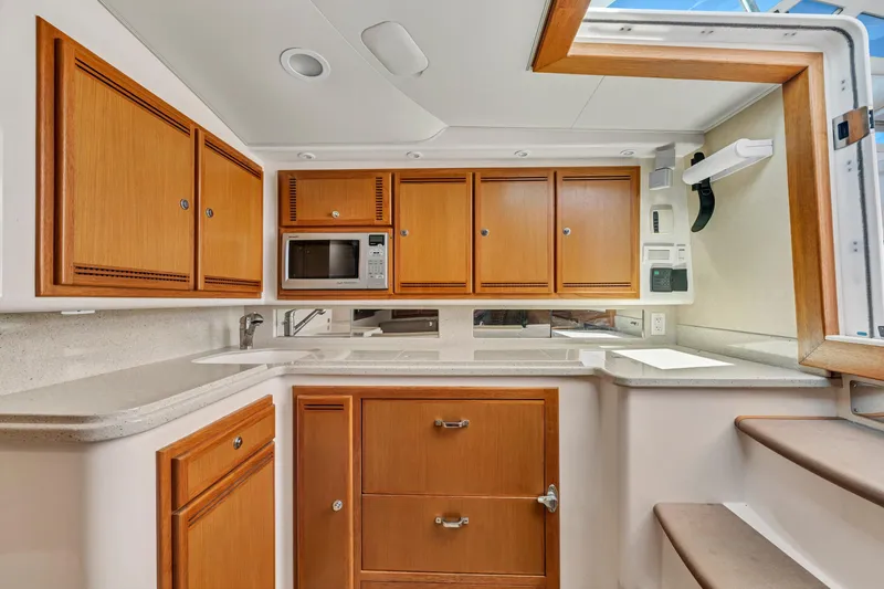 Slide: The Image of 2010 Cabo 45 Express yacht kitchen with wooden cabinets and modern appliances. - 22