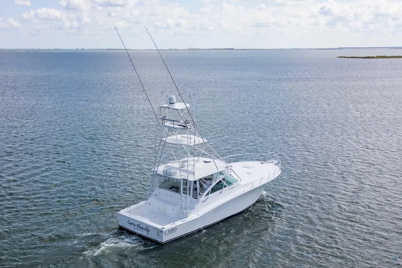 Slide: The Image of 2010 Cabo 45 Express boat cruising on open water under a cloudy sky. - 3