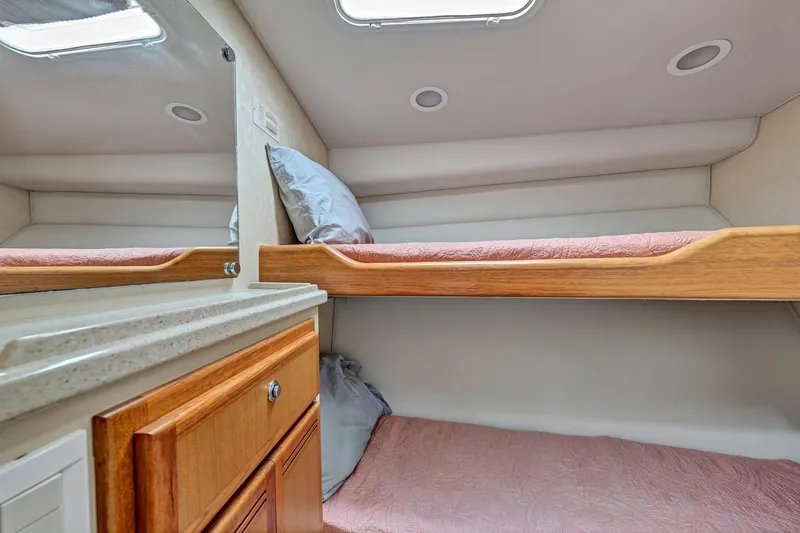 Slide: The Image of 2010 Cabo 45 Express cabin interior with bunk beds and wooden cabinetry. - 30