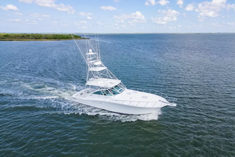 Slide: The Image of 2010 Cabo 45 Express yacht cruising on open water under a clear sky. - 4