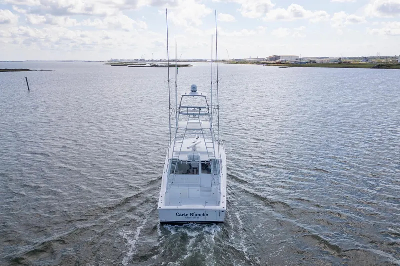 Slide: The Image of 2010 Cabo 45 Express yacht cruising on open water under a cloudy sky. - 5