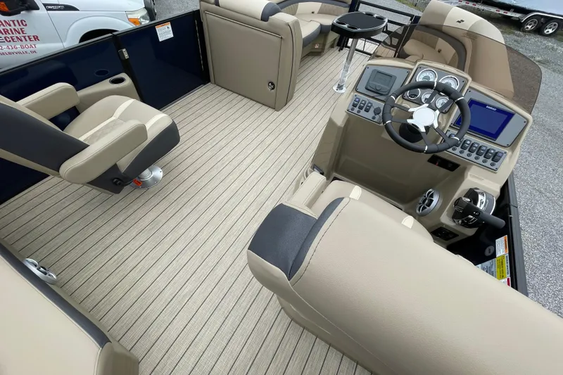 Slide: The Image of 2026 Starcraft EXS 5 Q DH boat interior with beige seating and cup holders. - 12