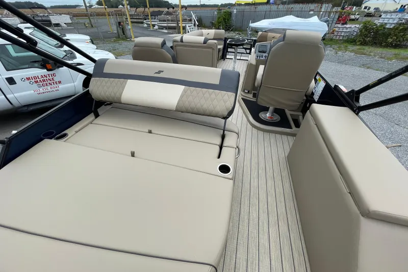 Slide: The Image of 2026 Starcraft EXS 5 Q DH boat deck with railing and motor, near blue building. - 16