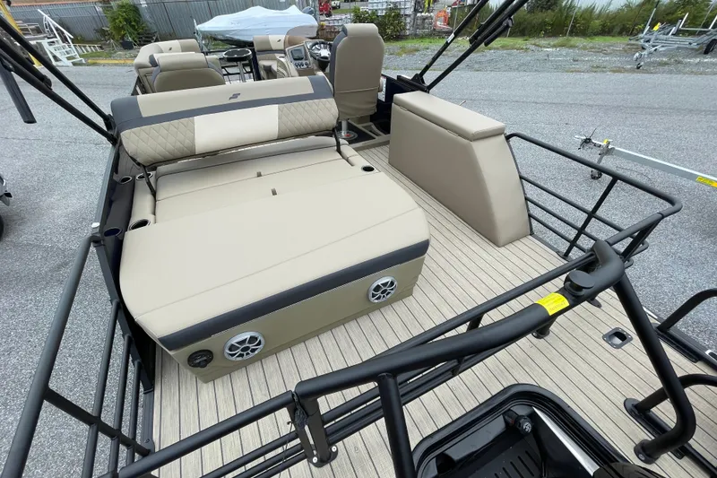 Slide: The Image of 2026 Starcraft EXS 5 Q DH pontoon boat with beige seating and canopy, parked outdoors. - 19