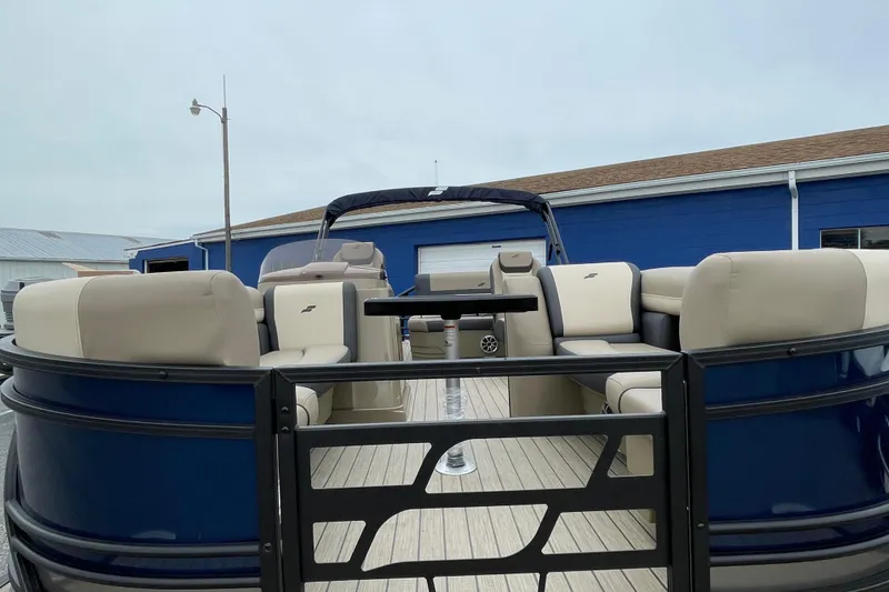 Slide: The Image of 2026 Starcraft EXS 5 Q DH pontoon boat with beige seating and blue exterior. - 3