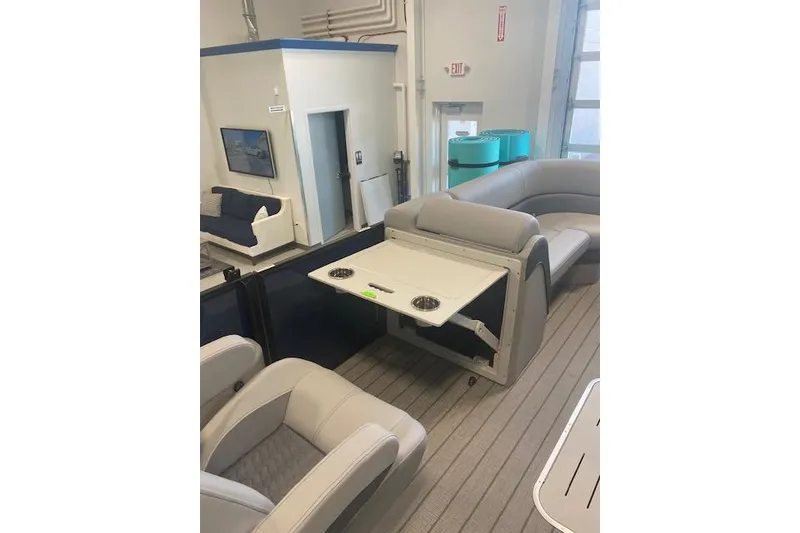 Slide: The Image of 2026 Bentley Pontoons Elite 223 Swingback interior with luxurious seating and table setup. - 17