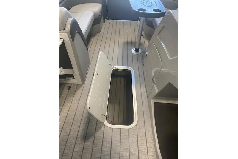 Slide: The Image of 2026 Bentley Pontoons Elite 223 Swingback interior with open storage compartment and seating. - 18