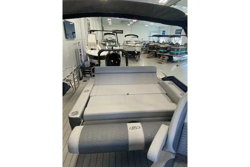 Slide: The Image of 2026 Bentley Pontoons Elite 223 Swingback interior, showcasing luxurious seating in a showroom. - 26