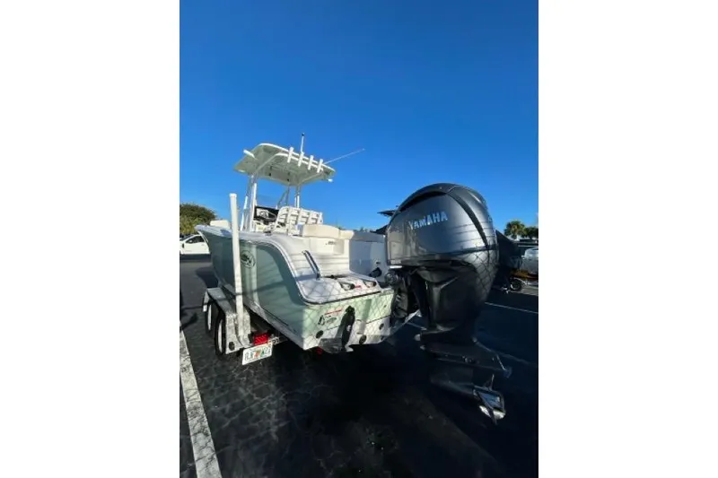 Slide: The Image of 2022 Sea Hunt Ultra 234 boat interior with seating, parked near vehicles. - 16