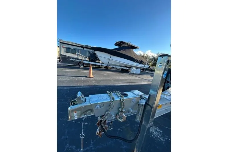 Slide: The Image of 2022 Sea Hunt Ultra 234 boat on trailer under clear blue sky. - 19
